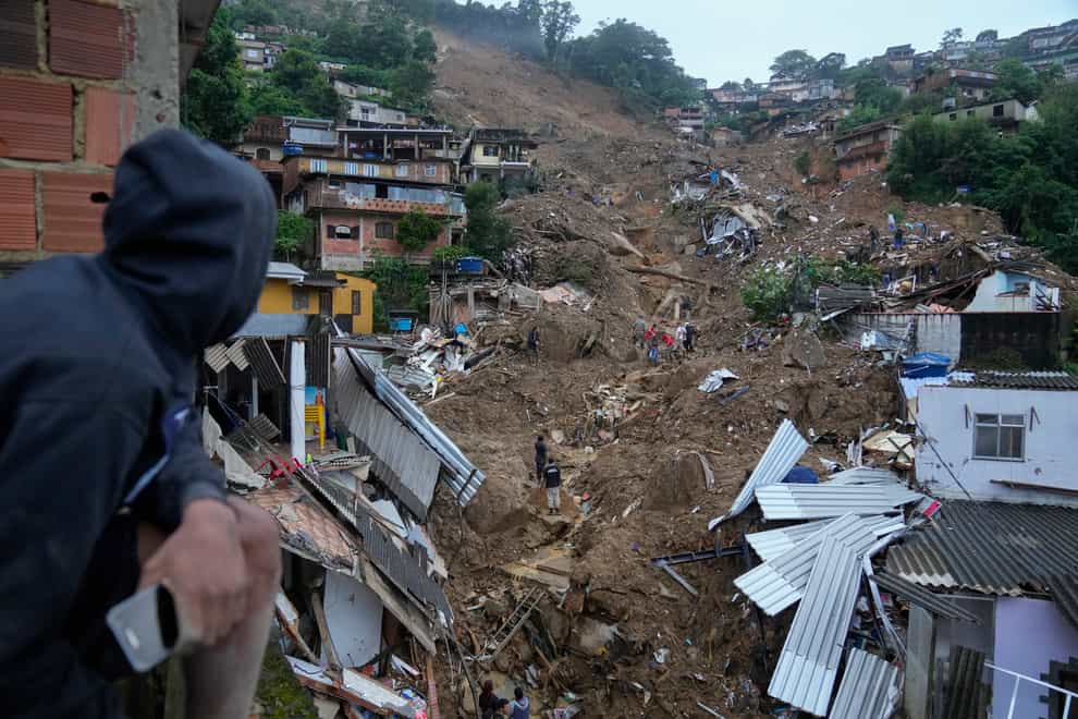 Rescue workers and residents search for victims in an area affected by landslides in Petropolis, Brazil, Wednesday, Feb. 16, 2022. Extremely heavy rains set off mudslides and floods in a mountainous region of Rio de Janeiro state, killing multiple people, authorities reported. (AP Photo/Silvia Izquierdo)