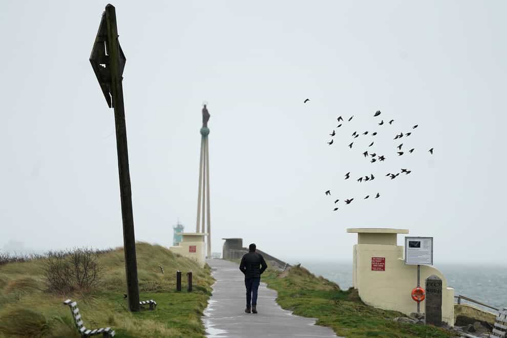 A man walks in strong winds on Bull Wall in Dublin as Storm Dudley makes its way over Ireland (Brian Lawless/PA)