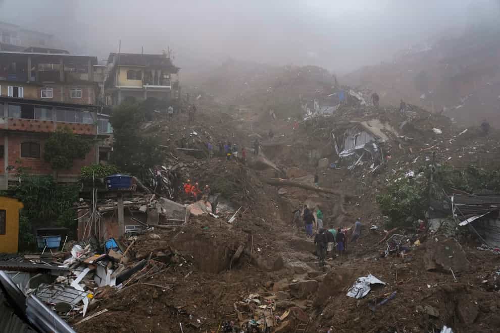 Rescue workers and residents look for victims in an area damaged by landslides in Petropolis, Brazil (Silvia Izquierdo/AP)