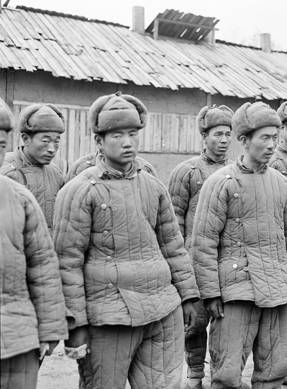 Chinese Communist troops wearing Manchurian winter gear line up for questioning in a prison stockade at Jamhung, North Korea (AP)