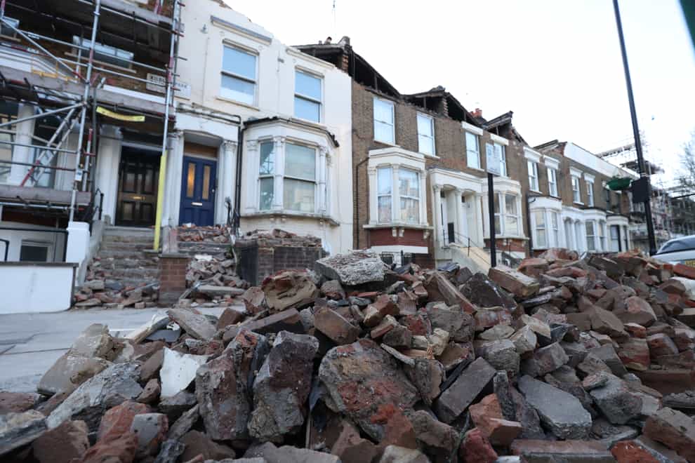 A roadside filled with debris from the rooftops of three houses which were torn off during storm Eunice, on Kilburn Park Road in north west London (James Manning/PA)