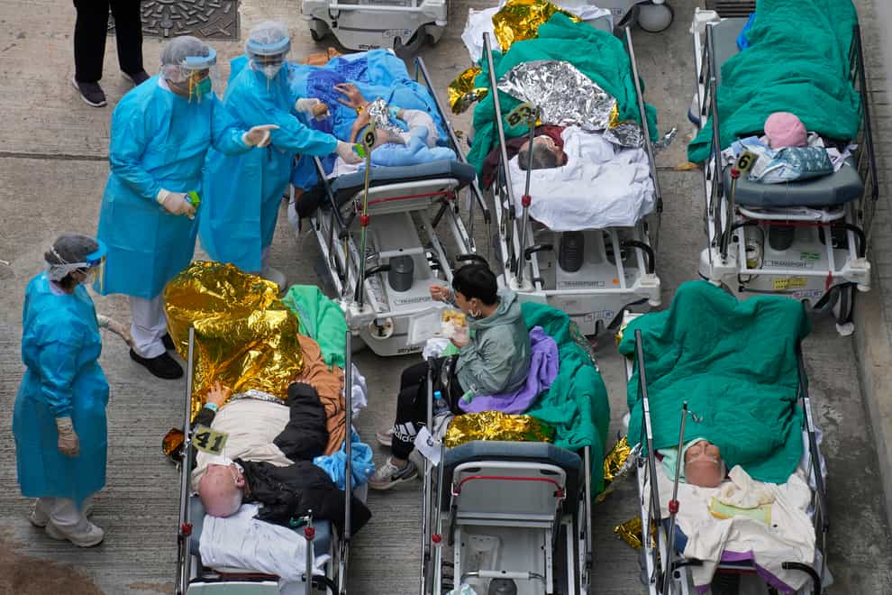 Patients lie on hospital beds as they wait at a temporary holding area outside Caritas Medical Centre in Hong Kong (Vincent Yu/AP)