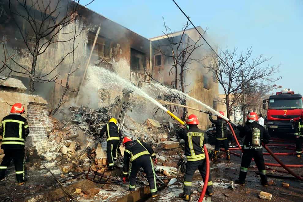 Firefighters extinguish the blaze at the scene of the fighter jet crash (Tasnim News agency via AP)