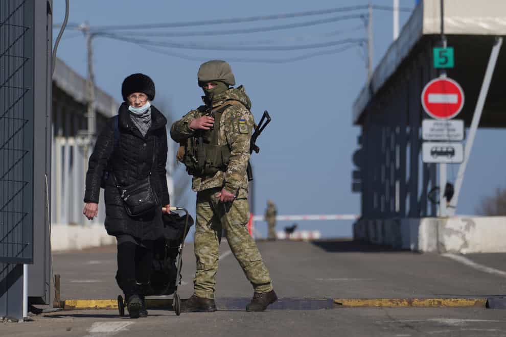 A woman crosses a checkpoint from the territory controlled by Russia-backed separatists to the territory controlled by Ukrainian forces in Novotroitske, eastern Ukraine (Evgeniy Maloletka/AP)