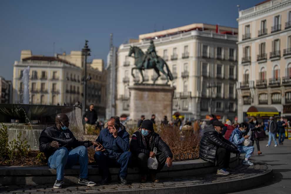 People, some of them without face masks to protect against coronavirus, gather in Madrid, Spain (Manu Fernandez/AP)