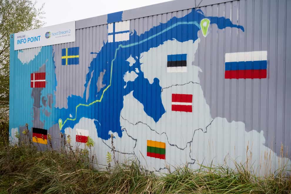A sign reading ‘Nord Stream 2 Committed, Reliable, Safe’ hangs above a painted map of the Nord Stream 2 pipeline from Russia to Germany at the natural gas receiving station in the Lubmin industrial estate in Lubmin, Germany (Stefan Sauer/dpa via AP)