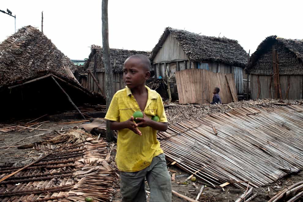 A child stands outside a ruined home in Mananjary, Madagascar (AP)