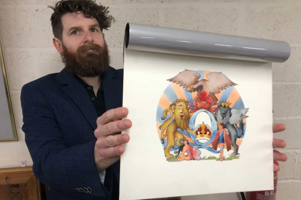 Auctioneer Luke Hobbs with David Costa’s original artwork for the 1976 Queen album A Day At The Races (Gardiner Houlgate/PA)