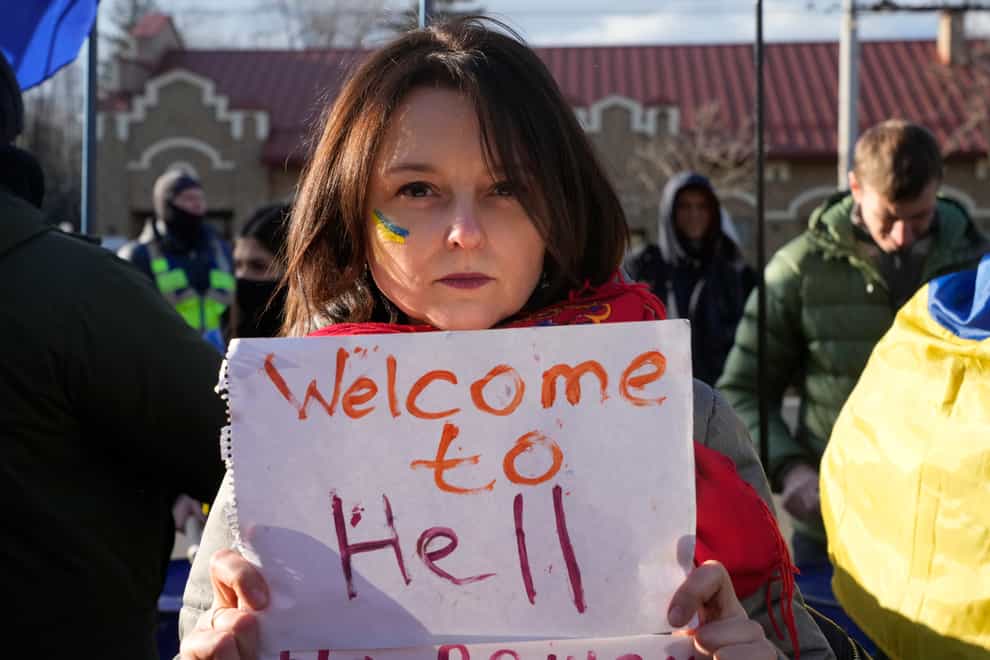 A protesters holds a poster during a rally in front of Russian Embassy in Kyiv, Ukraine, Tuesday, Feb. 22, 2022. Russia says that its recognition of independence for areas in eastern Ukraine extends to territory currently held by Ukrainian forces. That announcement Tuesday further raises the stakes amid Western fears that a full-fledged invasion of Ukraine is imminent. (AP Photo/Efrem Lukatsky)