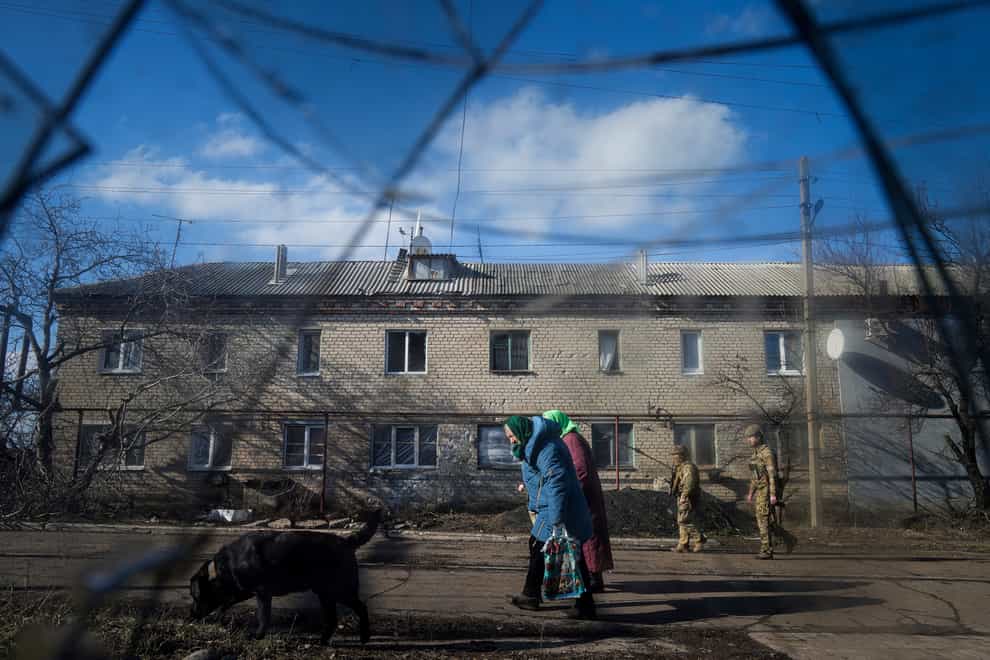 Two Ukrainian soldiers patrol a street (Evegenly Maloletka/AP)