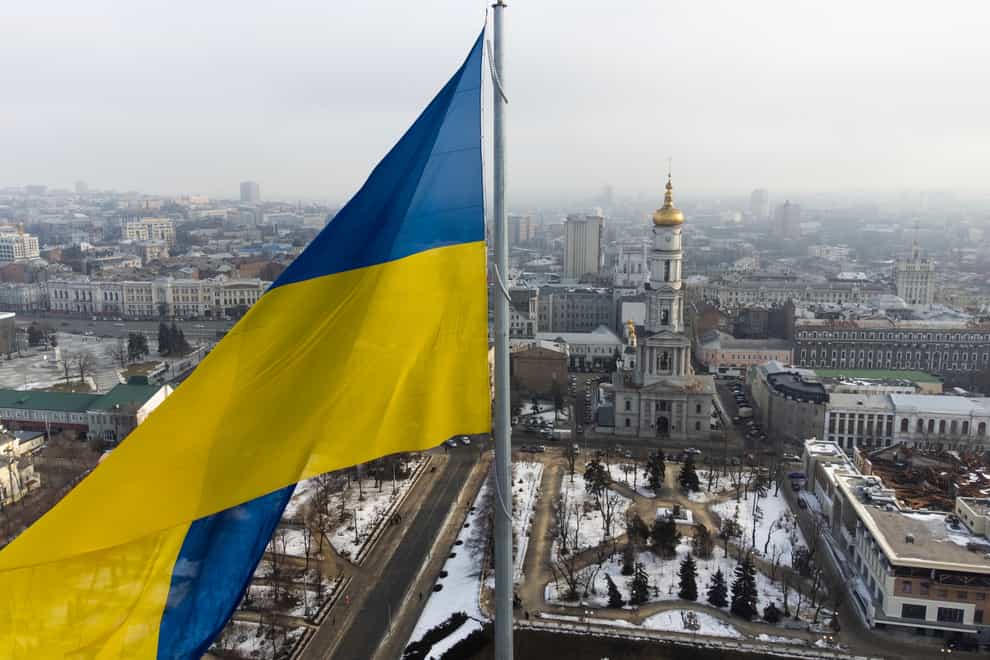 A Ukrainian national flag waves over the centre of Kharkiv, Ukraine’s second-largest city (Mstyslav Chernov/AP)