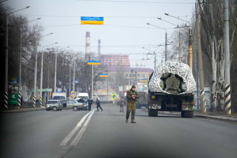 A Ukrainian soldier stands next to a military vehicle on a road in Kramatosrk, eastern Ukraine (Vadim Ghirda/AP)