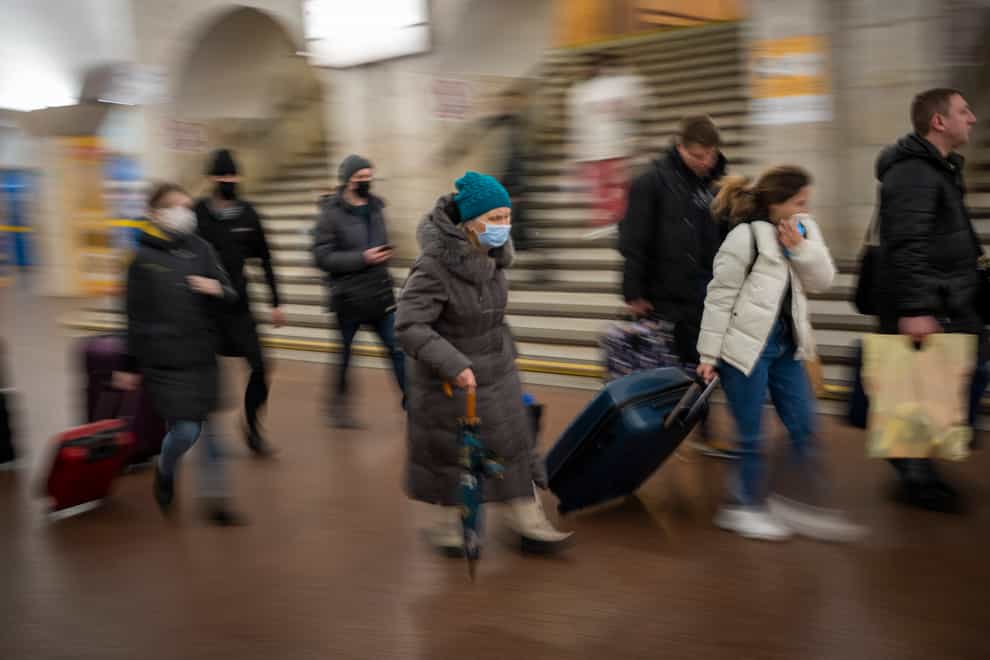 People walk in a subway to get a train as they leave Kyiv, Ukraine (Emilio Morenatti/AP)