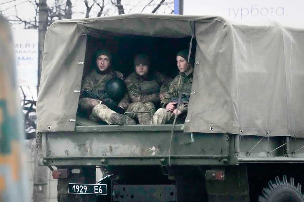 Ukrainian soldiers ride in a military vehicle in Mariupol, Ukraine (Sergei Grits/AP)
