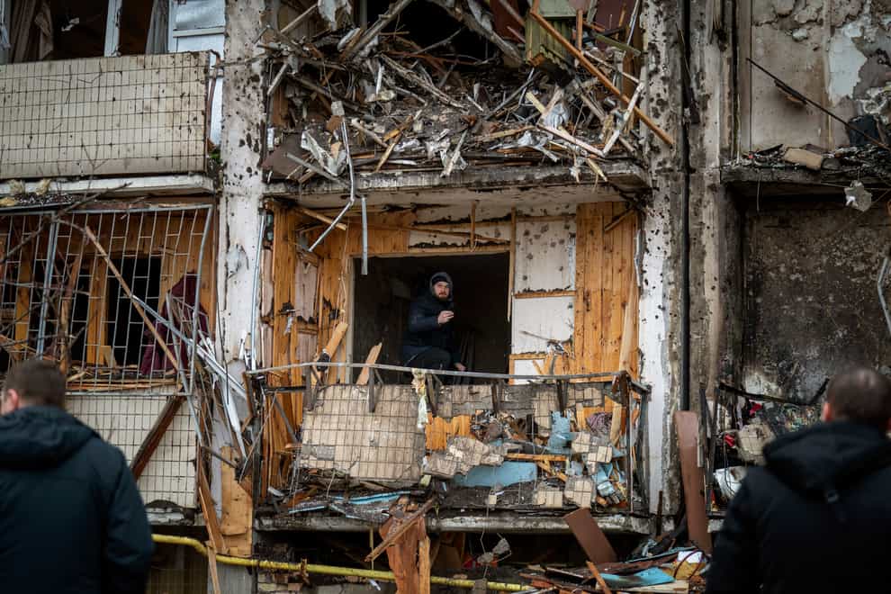 A man inspects damage at a building following a rocket attack on Kyiv (Emilio Morenatti/AP)