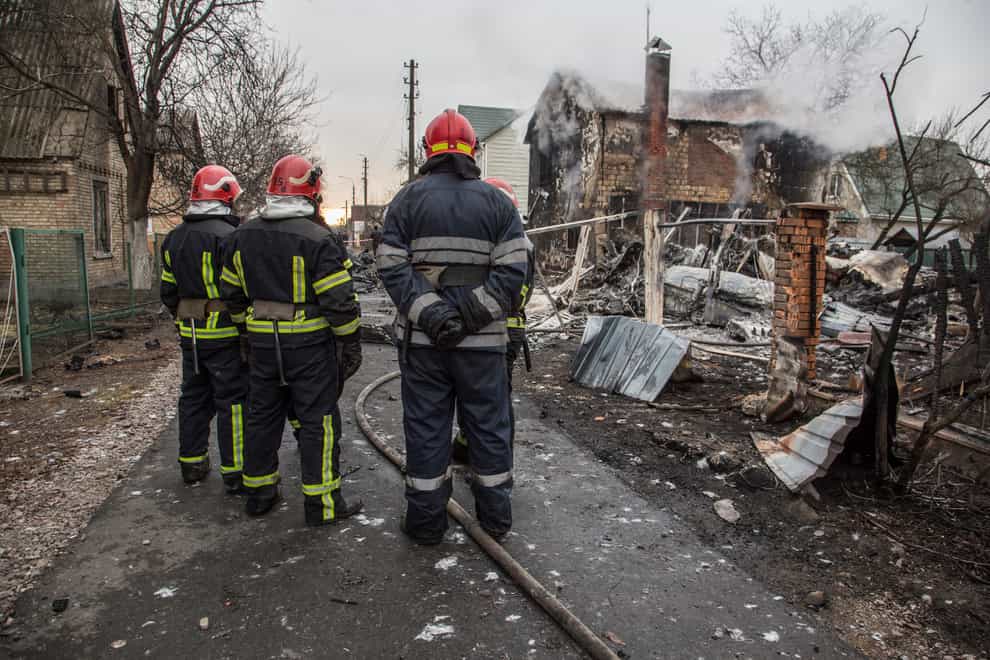 Ukrainian firefighters look at fragments of a downed aircraft in Kyiv (Oleksandr Ratushniak/AP)
