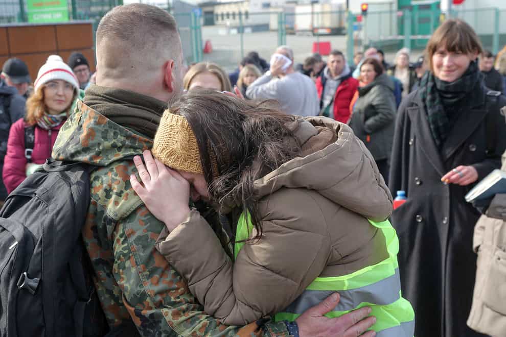 A Polish woman hugs a Polish volunteer waiting to cross the border to go and fight against Russian forces at Medyka border crossing in Medyka, Poland (Visar Kryeziu/AP)