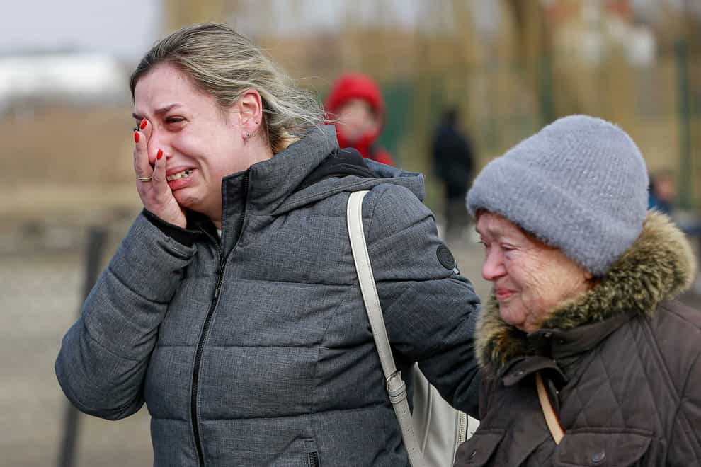 A Ukrainian woman reacts after arriving at the Medyka border crossing in Poland (Visar Kryeziu/AP)