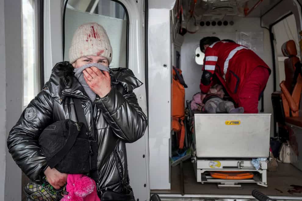 A woman reacts as paramedics perform CPR on the girl (Evgeniy Maloletka/AP)