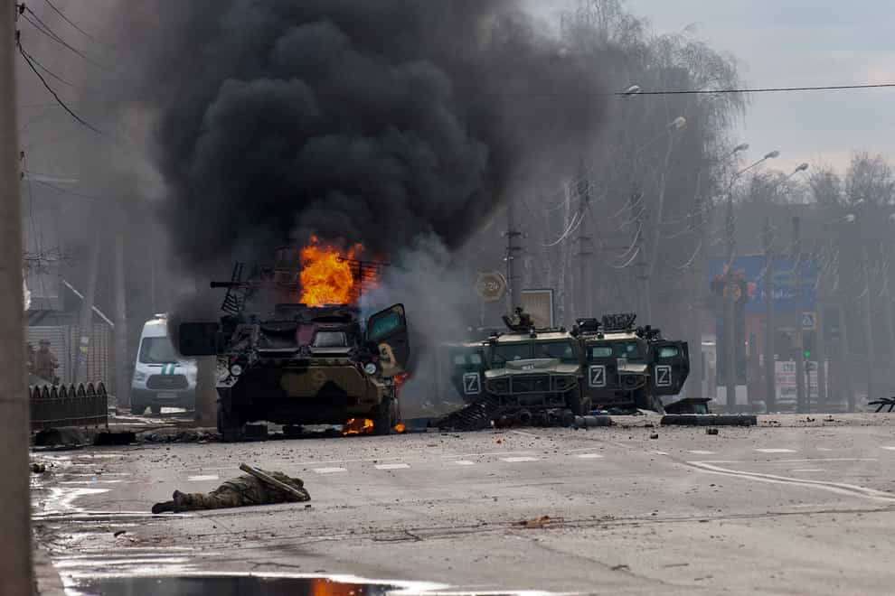 A Russian armoured personnel carrier burns amid damaged and abandoned light utility vehicles after fighting in Kharkiv, Ukraine (Marienko Andrew/AP)