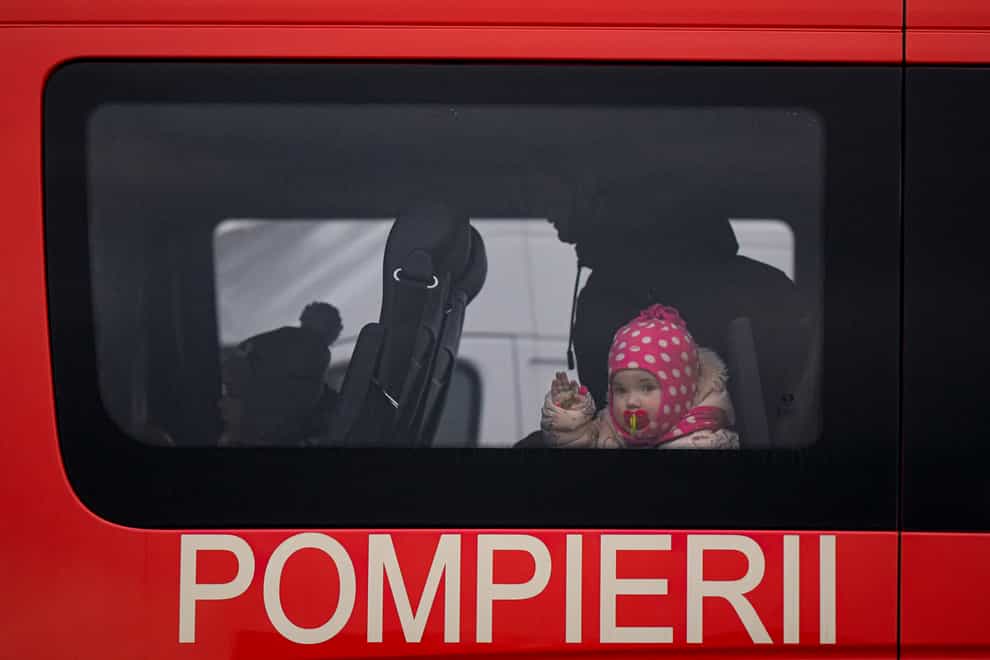 Refugees that fled the conflict from neighbouring Ukraine sit in a bus at the Romanian-Ukrainian border, in Siret (Andreea Alexandru/AP)