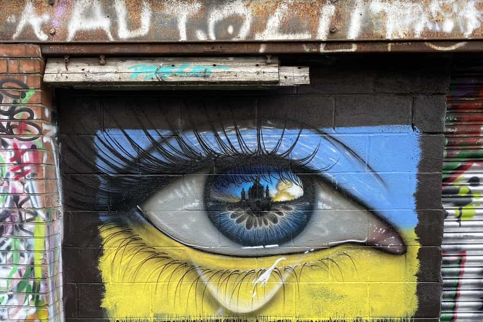 A mural in in Northcote Lane, Cardiff of a weeping eye in the colours of the Ukrainian flag by street artist MyDogSighs (MyDogSighs/PA)