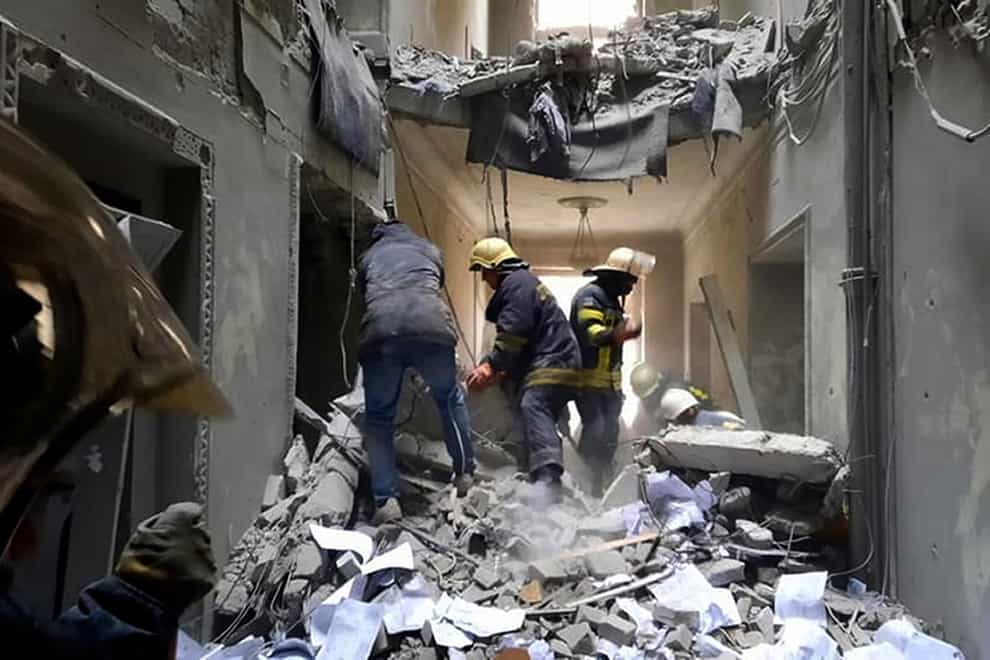 Emergency service personnel inspecting the damage inside the City Hall building in Kharkiv, Ukraine (Ukraine Emergency Service/AP)
