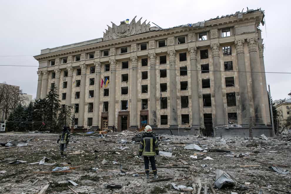 A member of the Ukrainian Emergency Service looks at the City Hall building in the central square following shelling in Kharkiv, Ukraine, on Tuesday March 1 2022 (AP Photo/Pavel Dorogoy)
