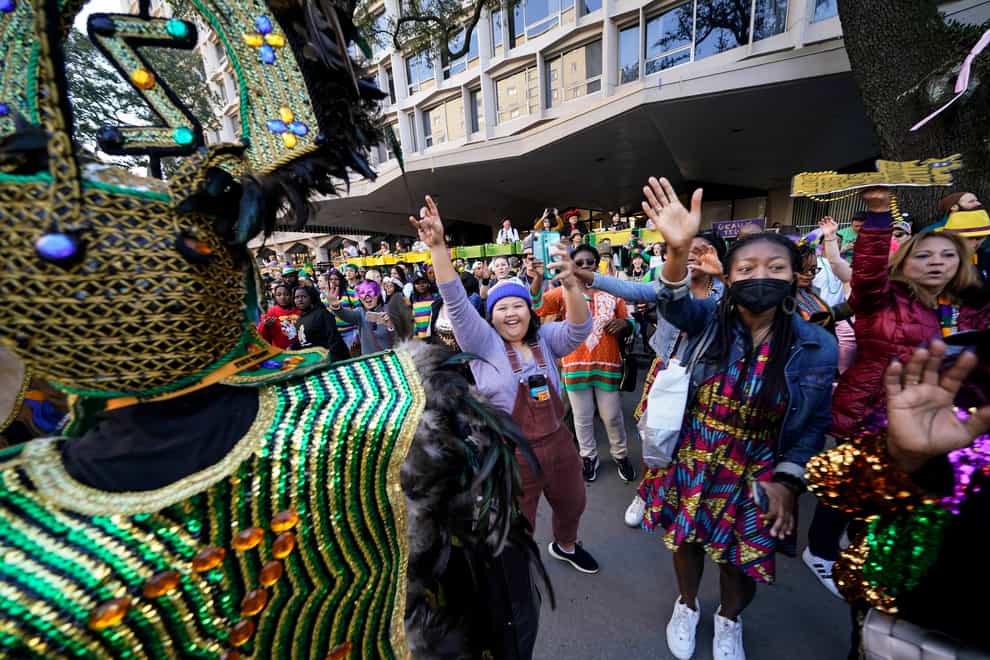 Parade goers cheer as the Krewe of Zulu parade passes during Mardi Gras (Gerald Herbert/AP)