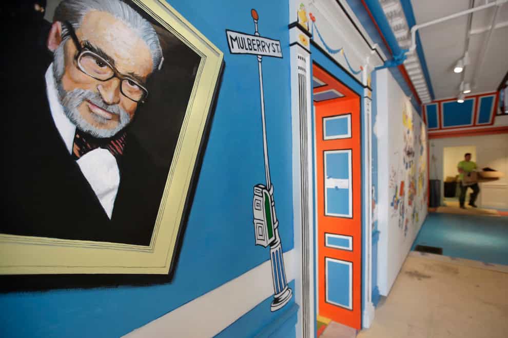 A mural that features Theodor Seuss Geisel, left, also known by his pen name Dr Seuss, covers part of a wall near an entrance at The Amazing World of Dr Seuss Museum (AP Photo/Steven Senne, File)