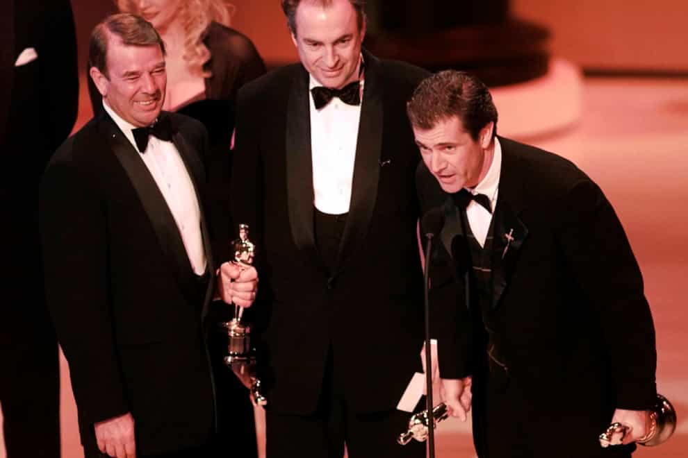 Mel Gibson, right, accepts the award for best picture for Braveheart at the Academy Awards in 1996, as co-producers Alan Ladd Jr, left, and Bruce Davey look on (Eric Draper/AP)