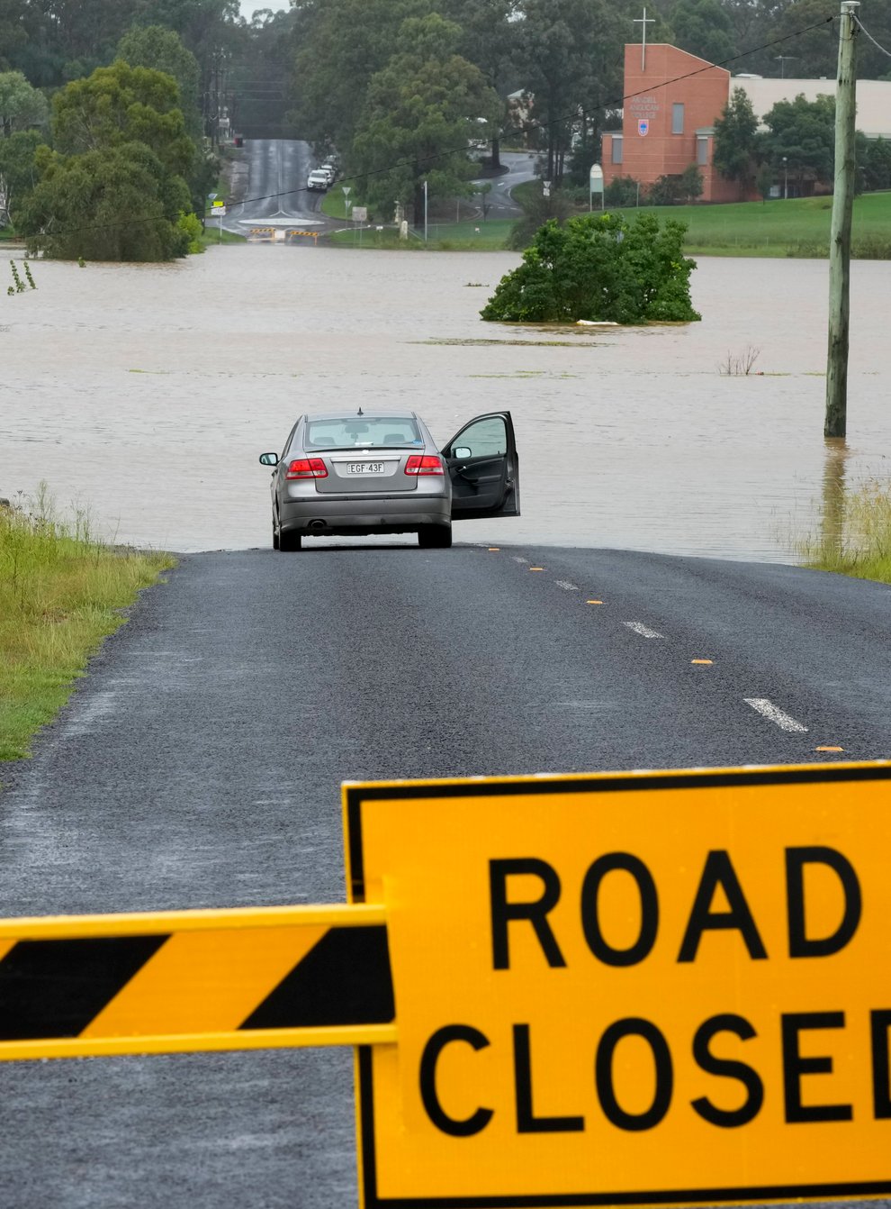 A car parked near a flooded road at Windsor on the outskirts of Sydney (Rick Rycroft/AP)