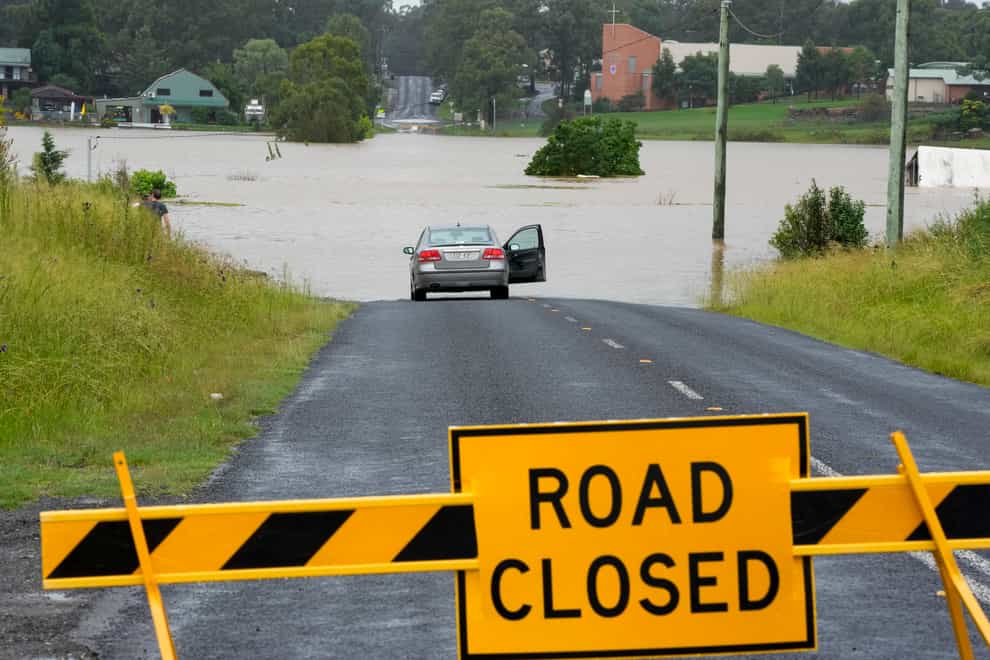 A car parked near a flooded road at Windsor on the outskirts of Sydney (Rick Rycroft/AP)