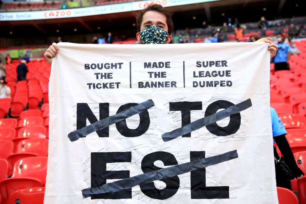 A fan in the stands holds up a banner protesting against the European Super League (Adam Davy/PA)