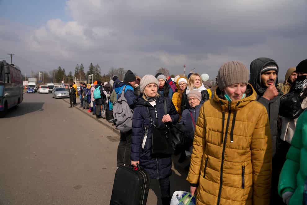 People fleeing from Ukraine queue to board on a bus at the border crossing in Medyka, Poland (Markus Schreiber/AP)