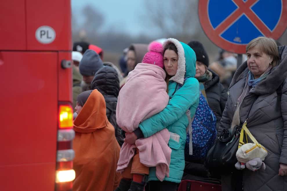 Refugees, mostly women with children, wait for transportation at the border crossing in Medyka, Poland (AP)
