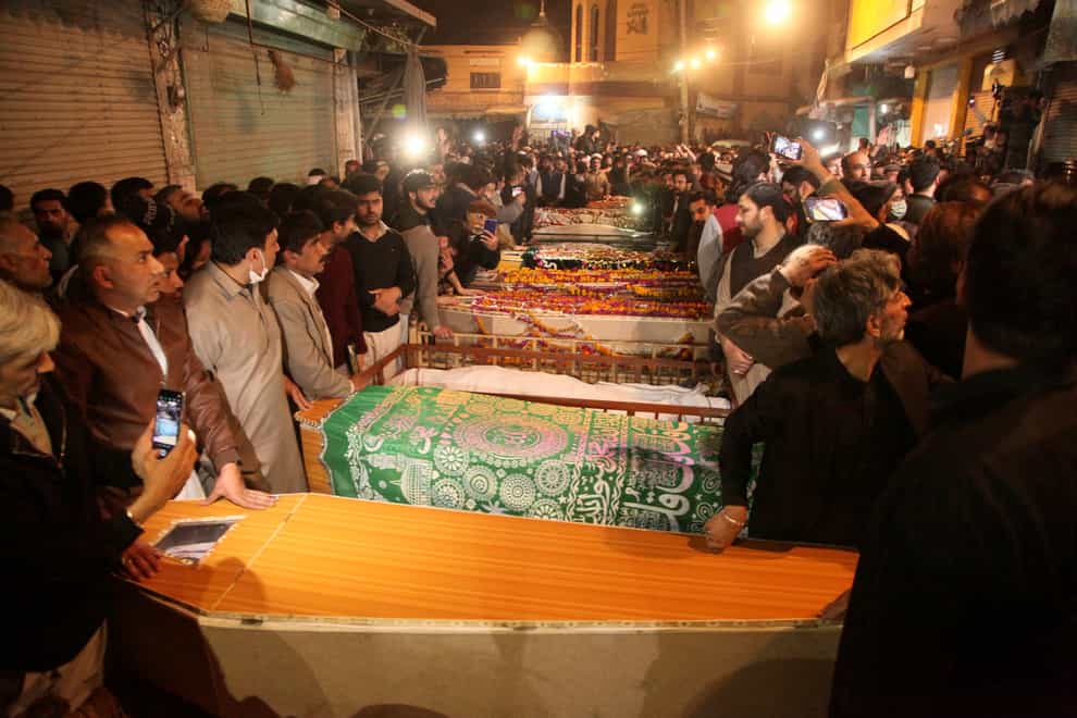 People attend funeral prayers for the victims of a suicide bombing in Peshawar (AP)