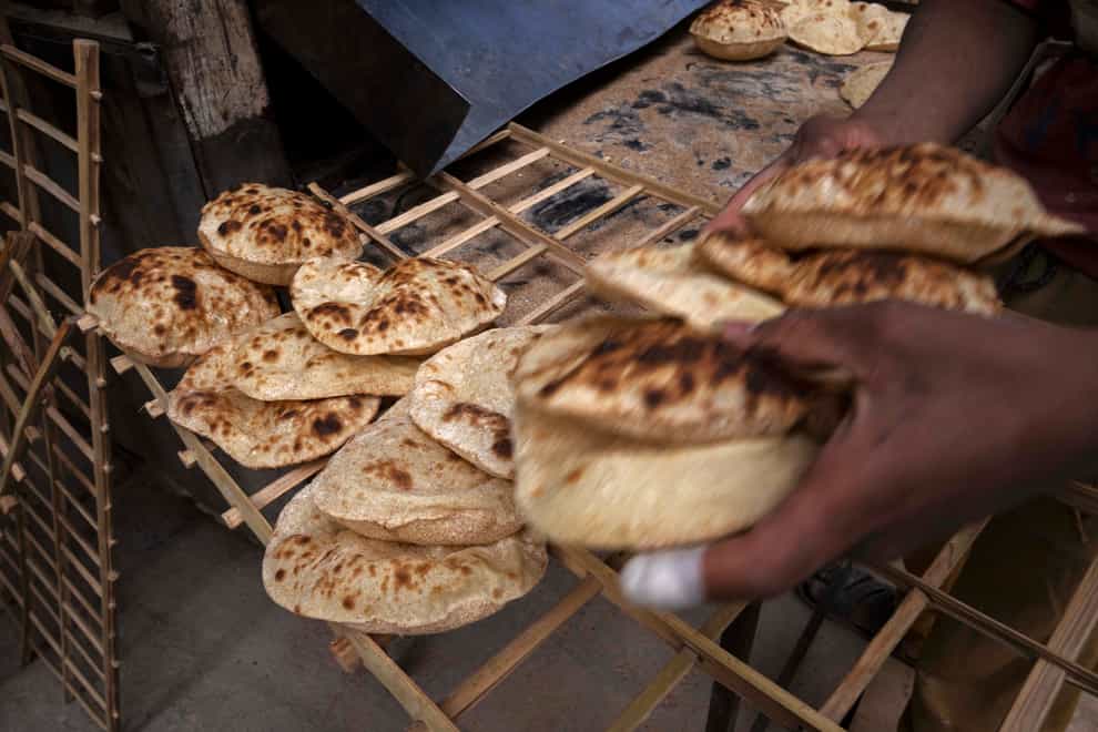 A worker collects Egyptian traditional ‘baladi’ flatbread, at a bakery in Cairo (Nariman El-Mofty/AP)