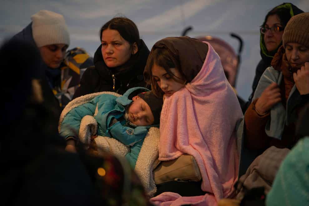 Refugees, mostly women with children, rest inside a tent after arriving at the border crossing in Medyka, Poland (Visar Kryeziu/AP)
