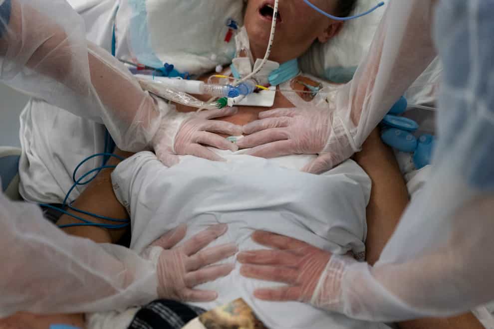 Nurses perform timed breathing exercises on a Covid-19 patient on a ventilator (Daniel Cole/AP)