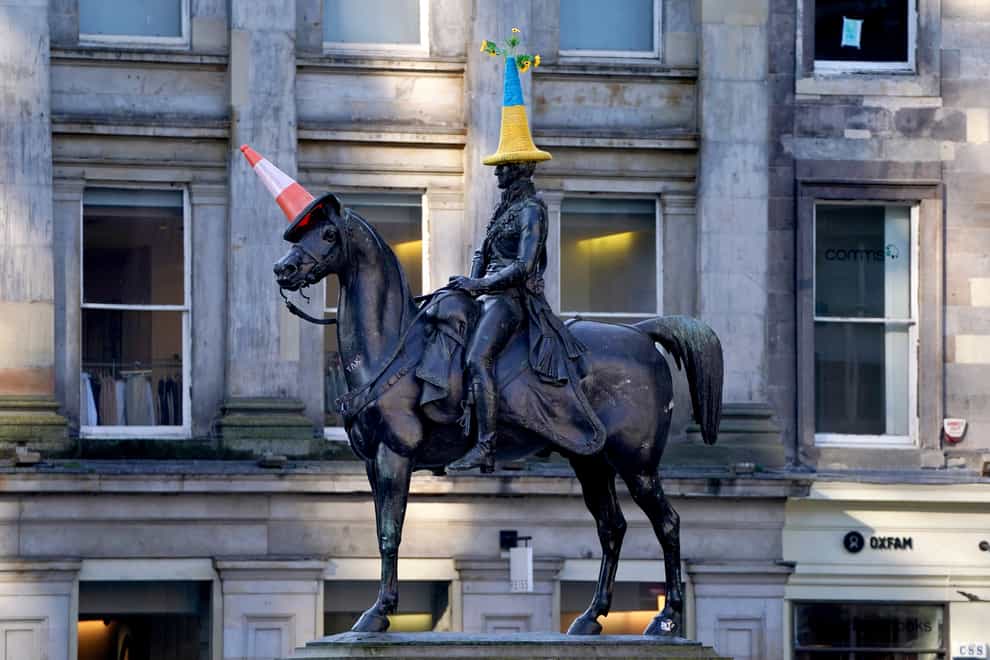 A traffic cone in the colours of the flag of Ukraine has been placed on top of the Duke of Wellington statue in Glasgow (Andrew Milligan/PA)