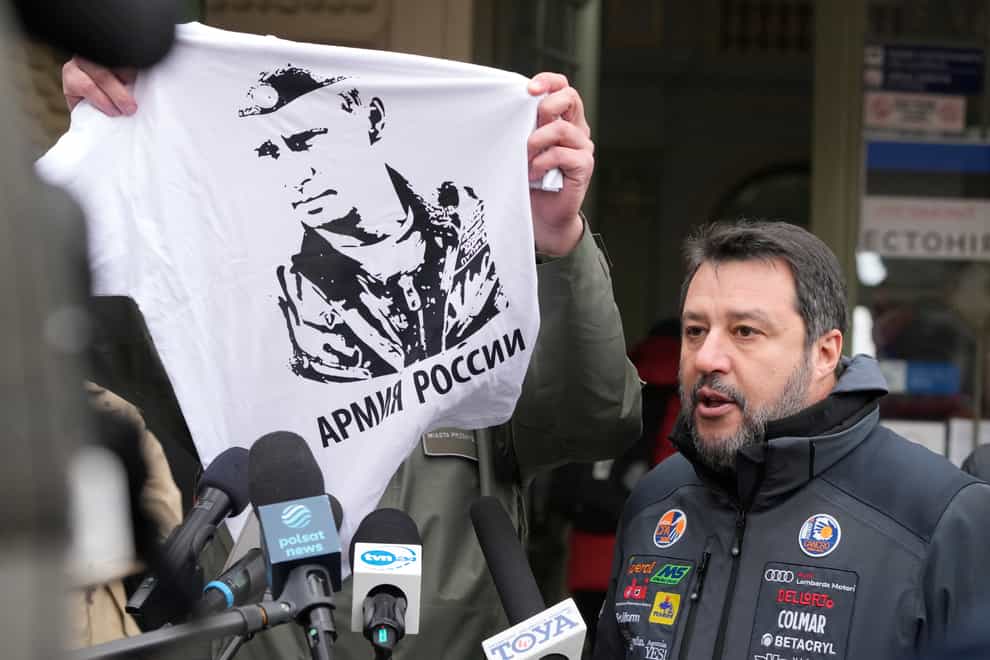 The Mayor of Przemysl, Wojciech Bakun, left, holds up a t-shirt with the likeness of Russian President Vladimir Putin and the words “The Russian Army” as Italy’s League Party leader, Matteo Salvini, right, speaks with journalists outside the train station in Przemysl, Poland, Tuesday, March 8, 2022. Matteo Salvini was confronted Tuesday by the mayor of Przemysl, Wojciech Bakun, during a news conference outside the train station where many of the more than 2 million refugees from war in Ukraine have come in recent days. (AP Photo/Czarek Sokolowski)