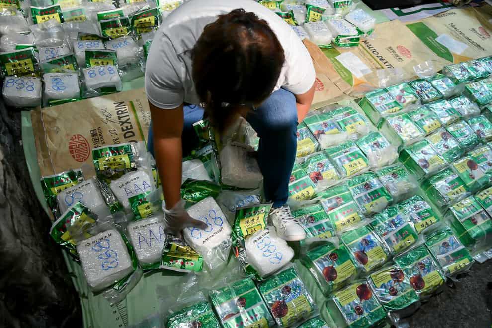 A man with bags of suspected methamphetamine estimated to be worth more than one billion pesos (£14.6m) seized in Manila (Philippine Drug Enforcement Agency Public Information Office/AP)