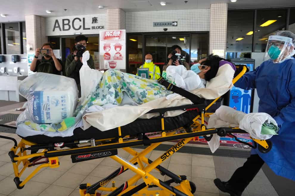 Medical staff transfer a non-Covid patient to another hospitals in Hong Kong as the Queen Elizabeth Hospital is to be dedicated to treating serious coronavirus patients (Kin Cheung/AP)