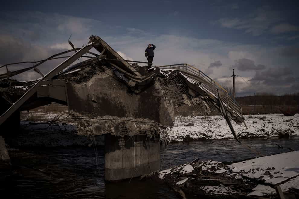 A man stands atop a destroyed bridge in Irpin, on the outskirts of Kyiv (Felipe Dana/AP)