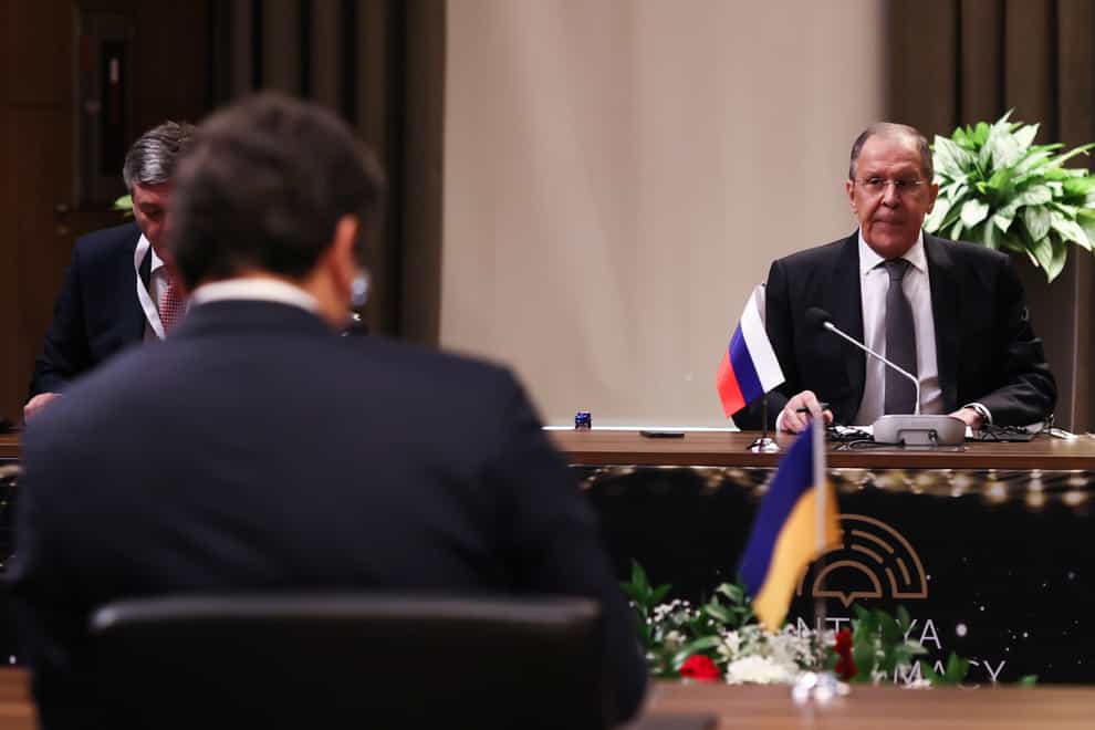 Russia’s Foreign Minister Sergei Lavrov sits in front of his Ukrainian counterpart Dmytro Kuleba, foreground left, during a tripartite meeting on Thursday March 10 2022 (Cem Ozdel/Turkish Foreign Ministry/AP)