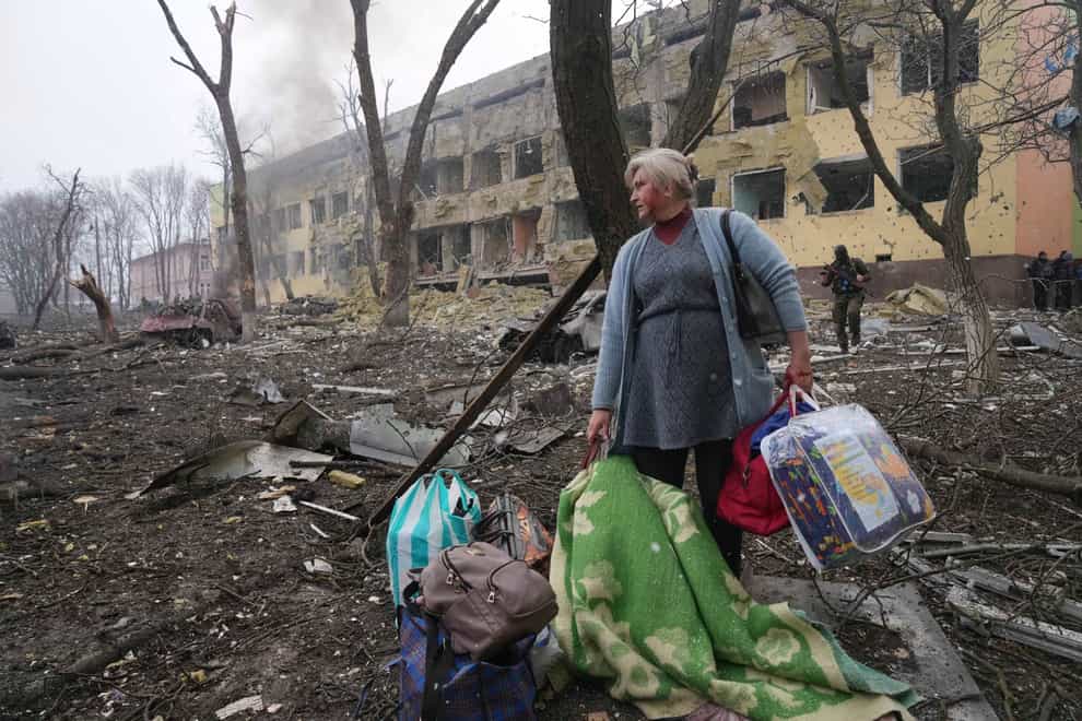 A woman walks outside a maternity hospital that was damaged by shelling in Mariupol, Ukraine (Evgeniy Maloletka/AP)