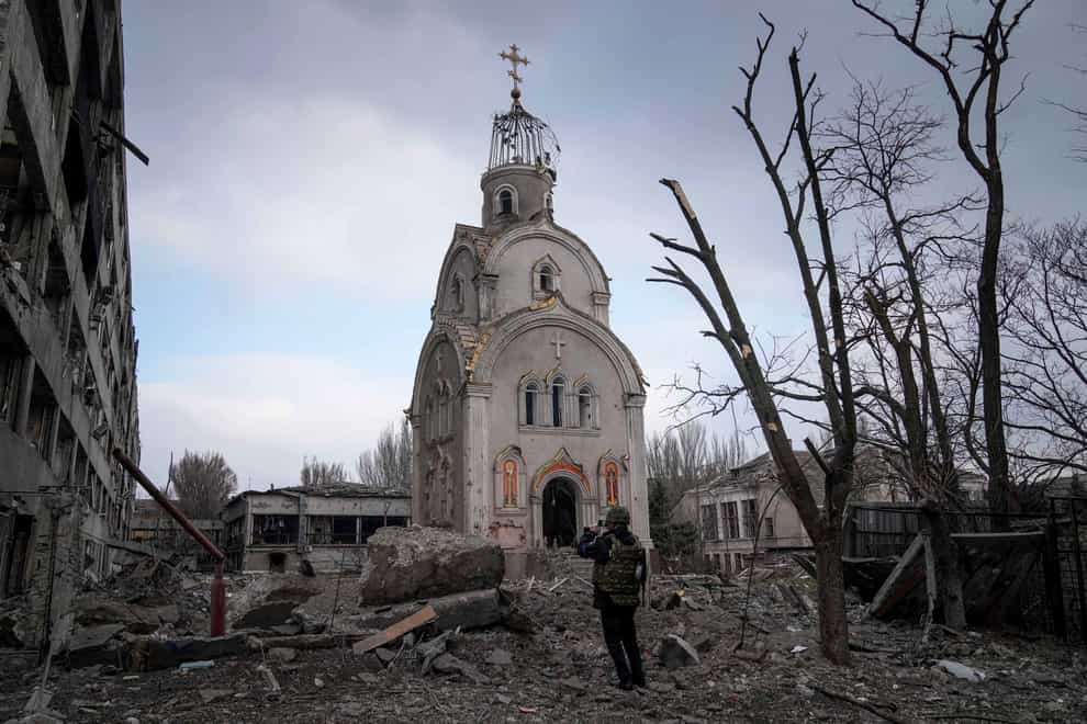 A Ukrainian serviceman takes a photograph of a damaged church after shelling in a residential district in Mariupol (AP Photo/Evgeniy Maloletka)