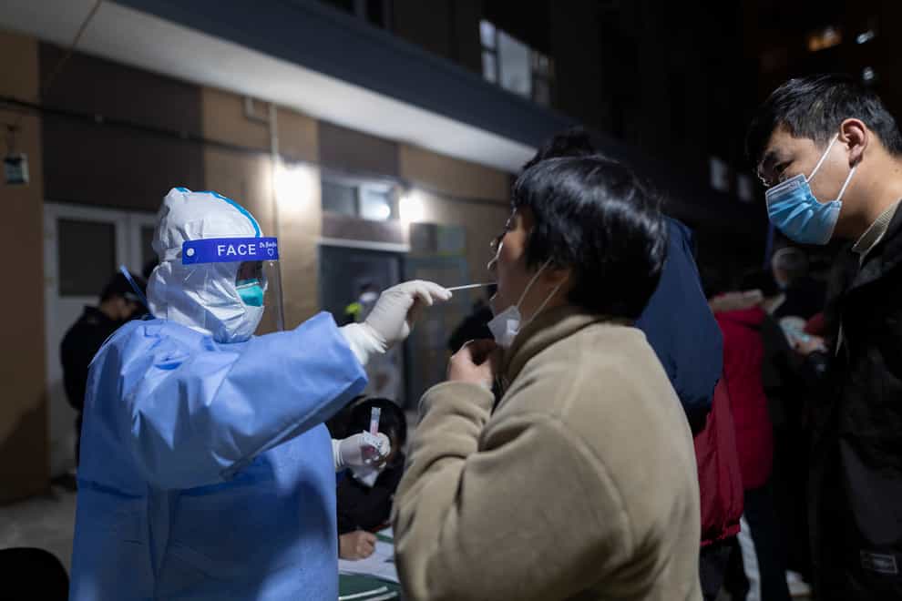 A woman gets her throat swabbed in Shanghai as part of China’s ‘zero tolerance’ strategy (AP)