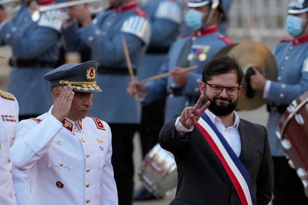 Chile’s new President Gabriel Boric flashes a victory hand gesture (Esteban Felix/AP)